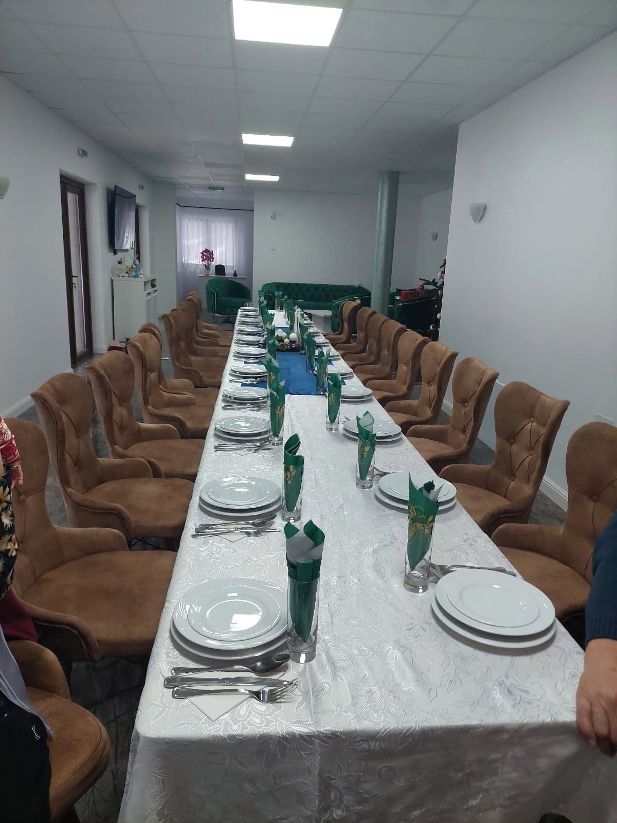 Sala de mese cu masă lungă pregătită pentru oaspeți